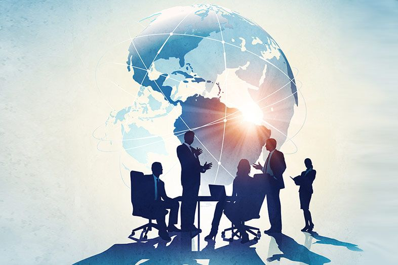 Global team collaboration with professionals around illuminated globe representing international business connectivity